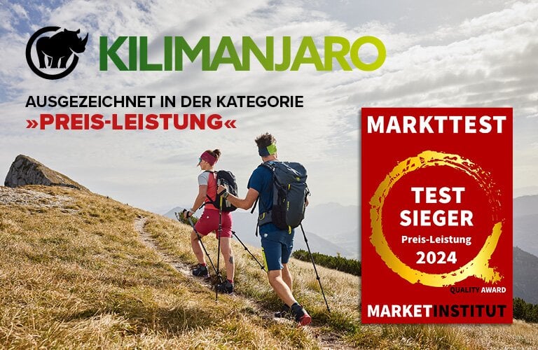 Zwei Wanderer auf einem Bergpfad mit Gras und Felsen. Text: 'KILIMANJARO AUSGEZEICHNET IN DER KATEGORIE »PREIS-LEISTUNG«'. Rotes Abzeichen: 'MARKTTEST TEST SIEGER Preis-Leistung 2024 QUALITY AWARD MARKETINSTITUT'.