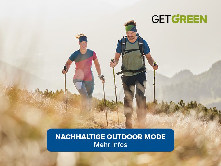 Zwei Personen wandern umgeben von Natur, mit Bergen im Hintergrund. Der Text auf dem Bild lautet: 'NACHHALTIGE OUTDOOR MODE Mehr Infos'. Im oberen rechten Eck befindet sich ein Logo mit der Aufschrift 'GET GREEN'.