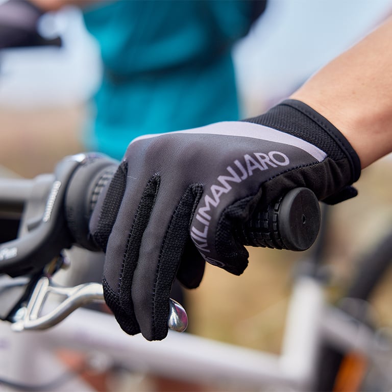Hand mit Fahrrad-Handschuh am Fahrradlenker.