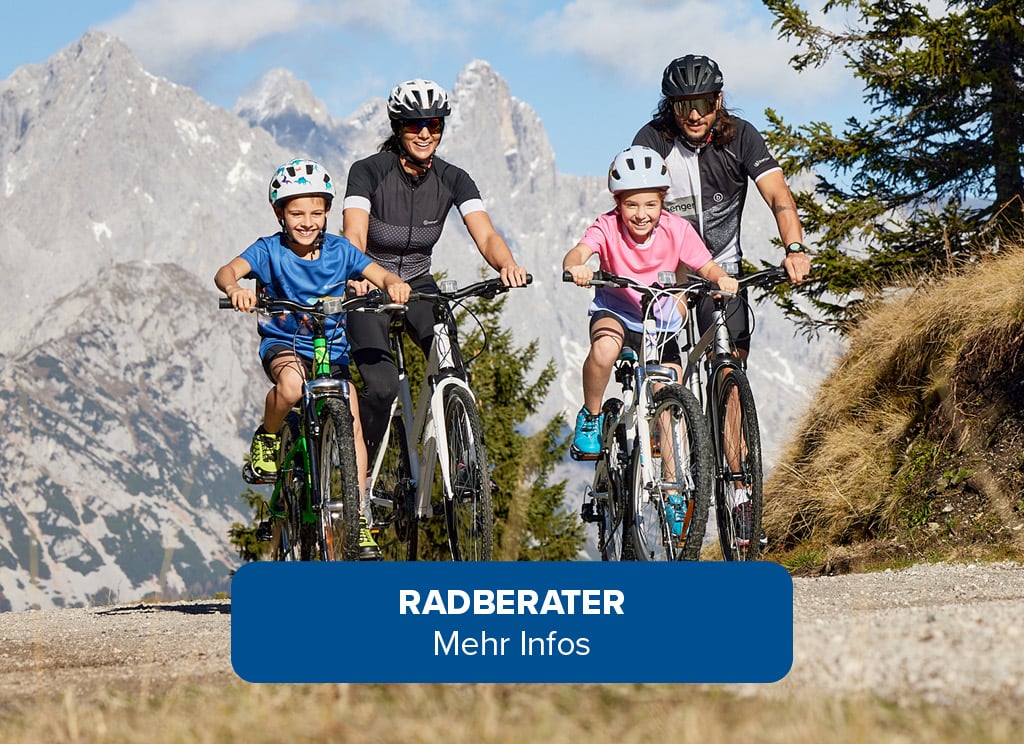 Vier Personen fahren mit Fahrrädern auf einem Bergweg. Im Hintergrund sind Berge und Bäume zu sehen. Text im Bild: RADBERATER Mehr Infos.