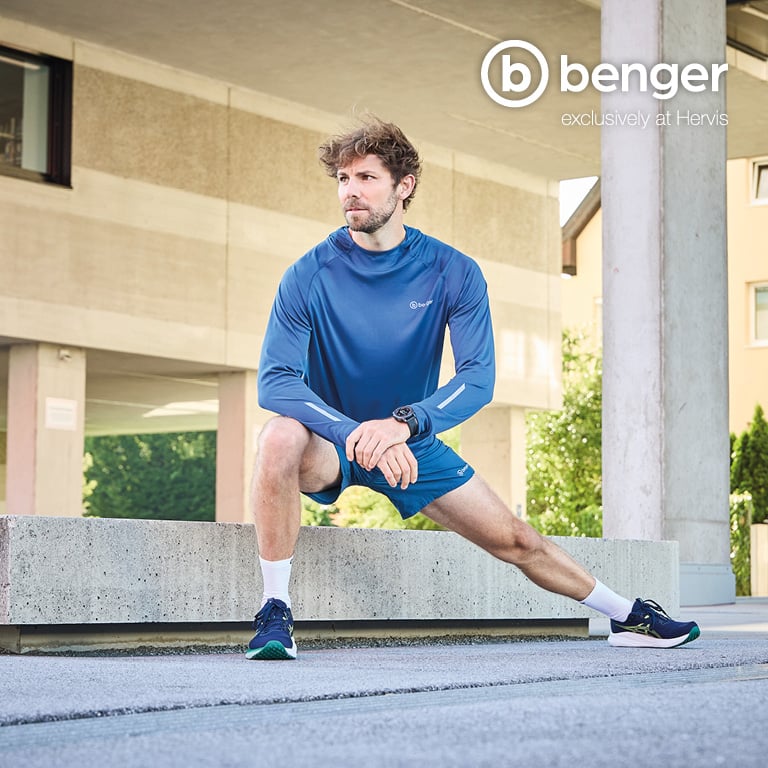 Eine Person in blauem Sportoberteil und blauer kurzer Hose macht einen seitlichen Ausfallschritt auf einer betonierten Fläche. Rechts oben im Bild befindet sich das Logo von benger mit dem Zusatz „exclusively at Hervis“.