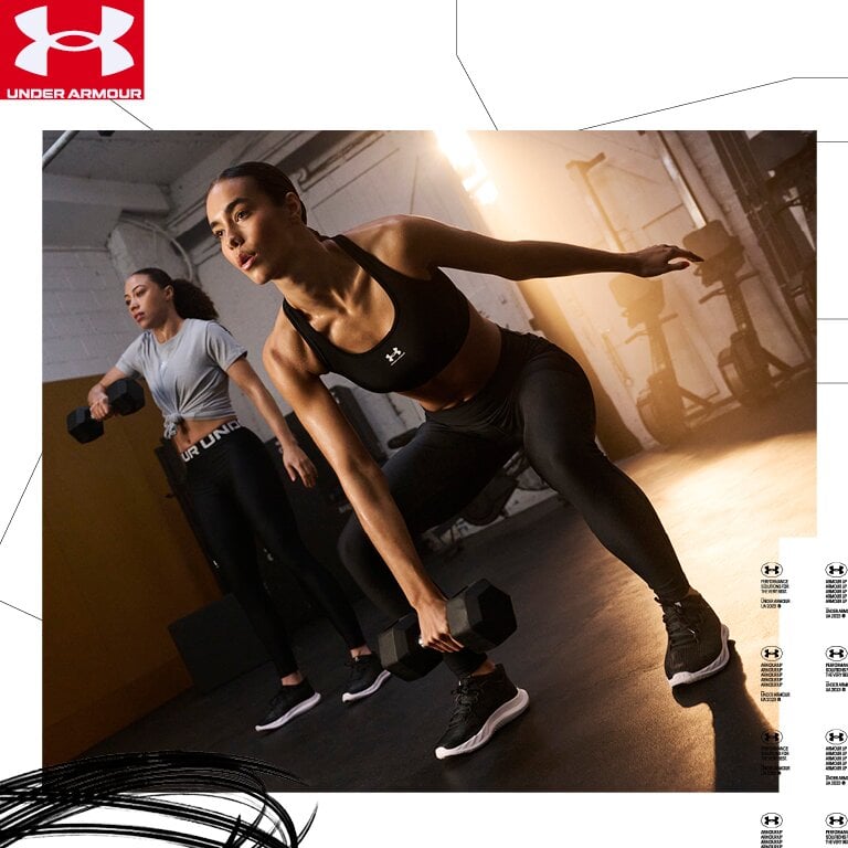 Zwei Frauen trainieren in einem Fitnessstudio. Das Under Armour-Logo ist auf ihrer Kleidung gut sichtbar.