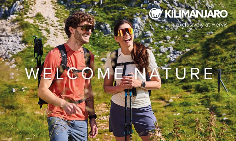 Kilimanjaro. Exclusively at Hervis. Welcome Nature. Zwei Personen machen eine Schneeschuhwanderung in einer verschneiten Landschaft. 