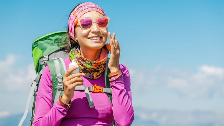 Wanderer cremt sich bei Sonnenschein das Gesicht ein