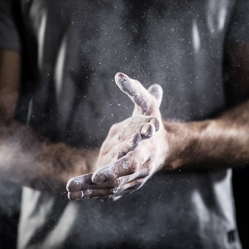 Eine Person reibt ihre Hände mit Chalk ein.