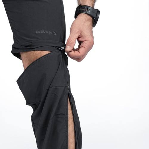 Person zieht Schwarze Zipp-Off Wanderhose an