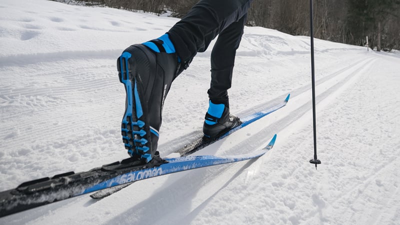 Ein Langläufer stößt sich in der Loipe mit dem Ski nach hinten ab.