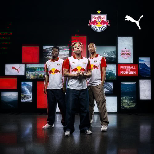 Drei Personen in Red Bull Salzburg-Trikots stehen vor einem Hintergrund aus Landschafts- und Stadtbildern sowie Logos von Red Bull Salzburg und Puma. Im Vordergrund befindet sich ein rotes Textfeld mit der Aufschrift ‚FUSSBALL VON MORGEN‘.