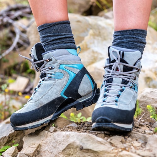 Graueblaue Wanderschuhe auf felsigem Untergrund in Nahaufnahme.