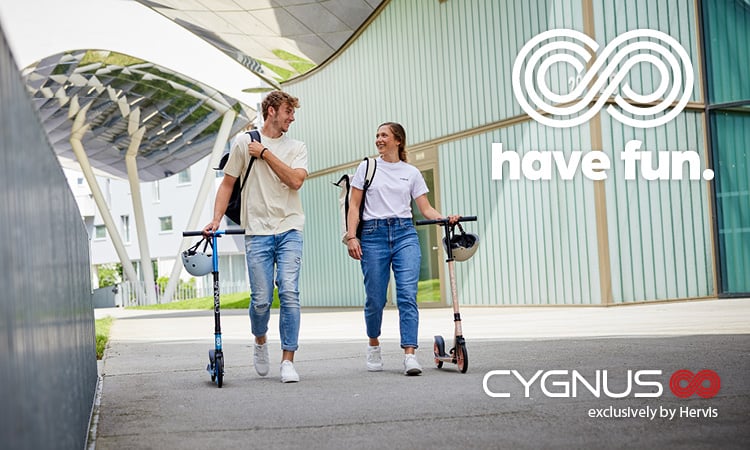 Have fun. Cygnus exclusively by Hervis. Zwei junge Personen in lässigen Outfits schlendern durch die Gegend, die schieben Scooter neben sich her. 