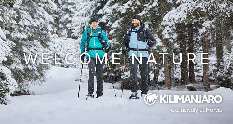 Kilimanjaro Kilimanjaro. Exclusively at Hervis. Welcome Nature. Zwei Personen machen eine Schneeschuhwanderung in einer verschneiten Landschaft.