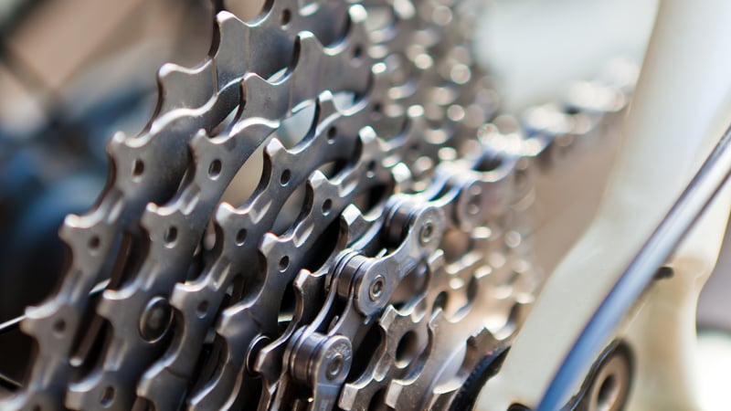 Nahaufnahme des hinteren Fahrradkassettenritzels mit mehreren unterschiedlich großen Zahnkränzen. Die Kette ist um die Ritzel gelegt, der Fokus liegt auf den feinen Details und der Struktur der Metallkomponenten.